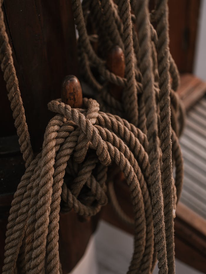 Detailed close-up of knotted ropes on a ship, offering a rustic nautical vibe.